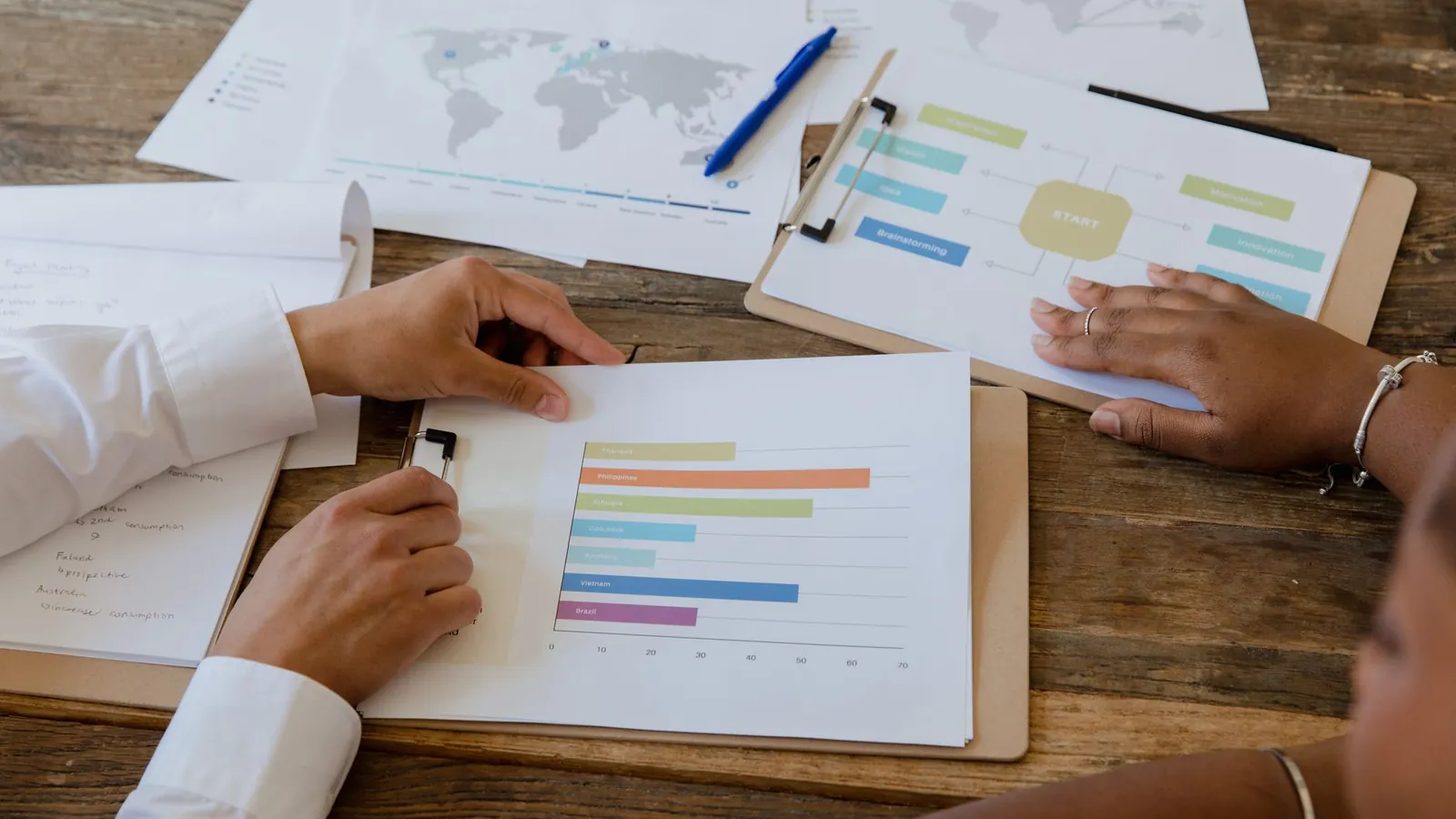 Une équipe relit des graphiques et un plan d’action posés sur une table de réunion